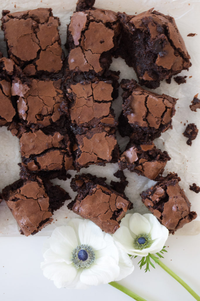 Brownies with crinkle tops on parchment paper