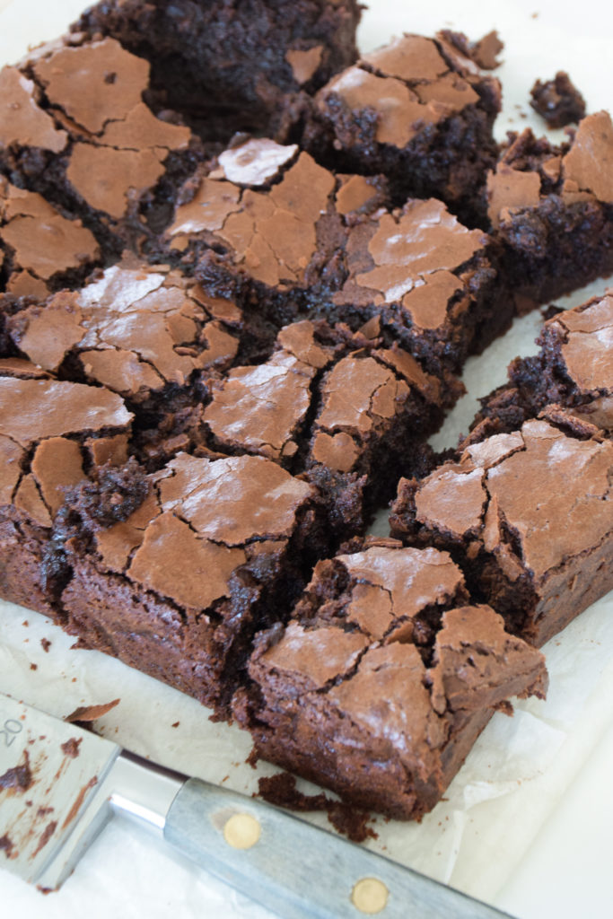 Brownies with crinkle tops on parchment paper