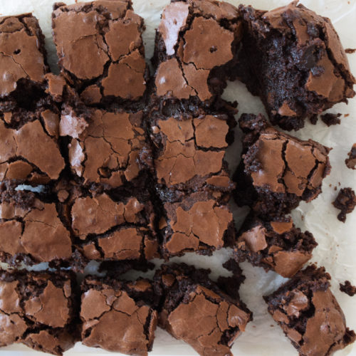 Brownies with crinkle tops on parchment paper