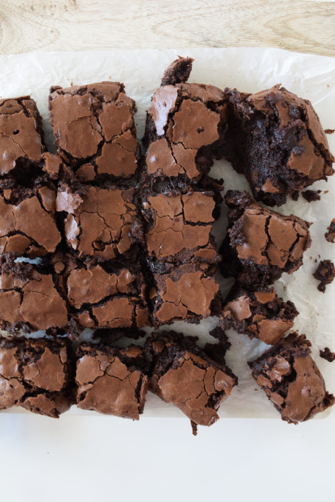 Brownies with crinkle tops on parchment paper